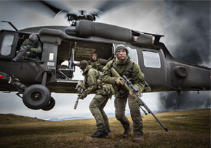 Two special operations forces scout snipers are dropped by a blackhawk helicopter.