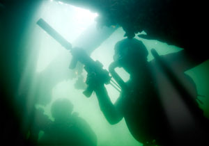 Two Special Operations Forces combat diver with silenced MP7 submachine guns.