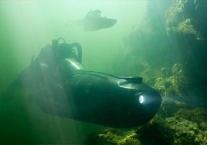 Two Special Operations Forces combat diver with diver propulsion vehicle.